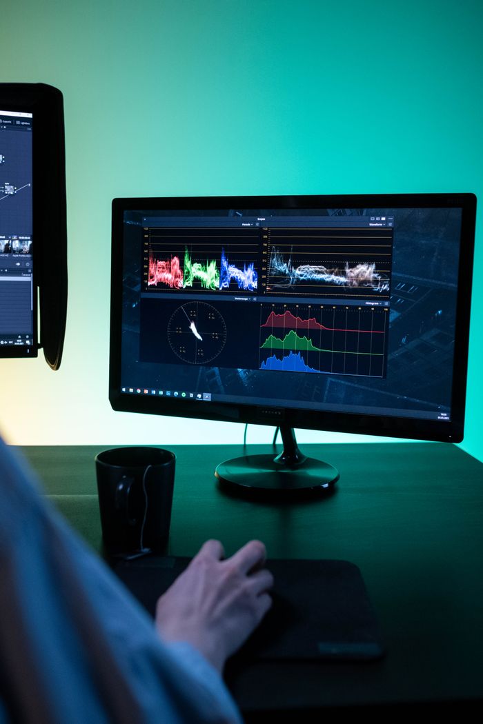 our-story-01 Modern workspace setup with dual monitors showcasing editing software and data analysis.