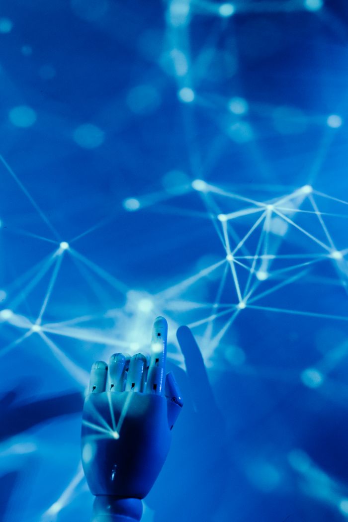 services-01 Futuristic robotic hand touching a digital network on a blue background.